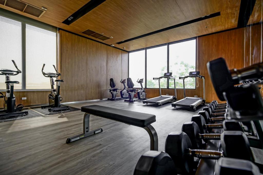 A compact, windowed gym offers treadmills, exercise bikes, dumbbells, and a bench.