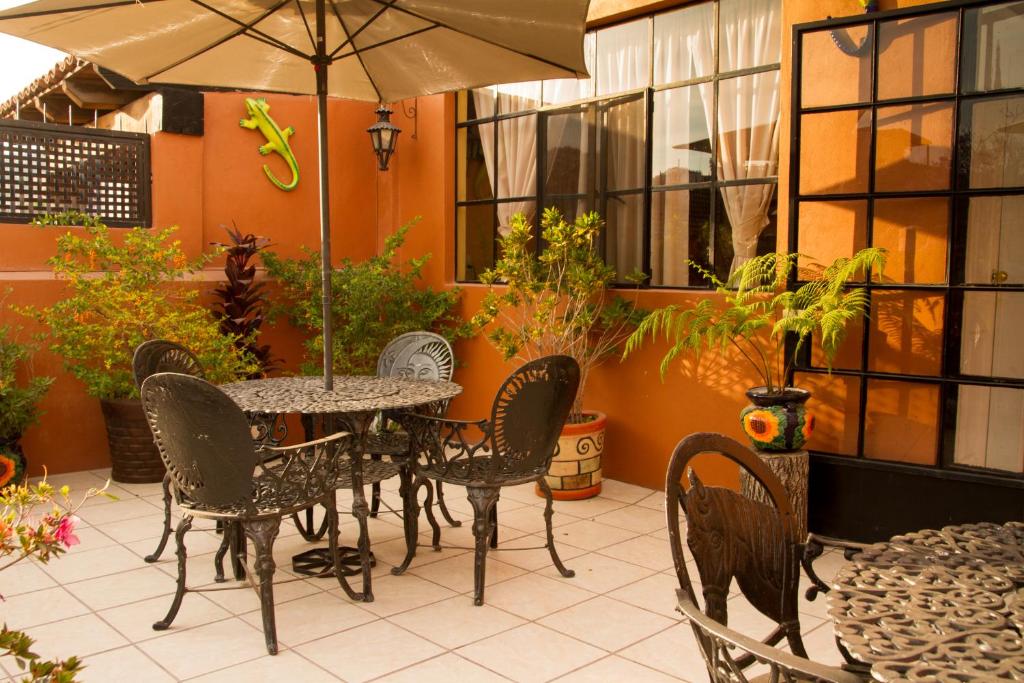 a table and chairs with an umbrella on a patio at Posada Maria Luisa in San Miguel de Allende