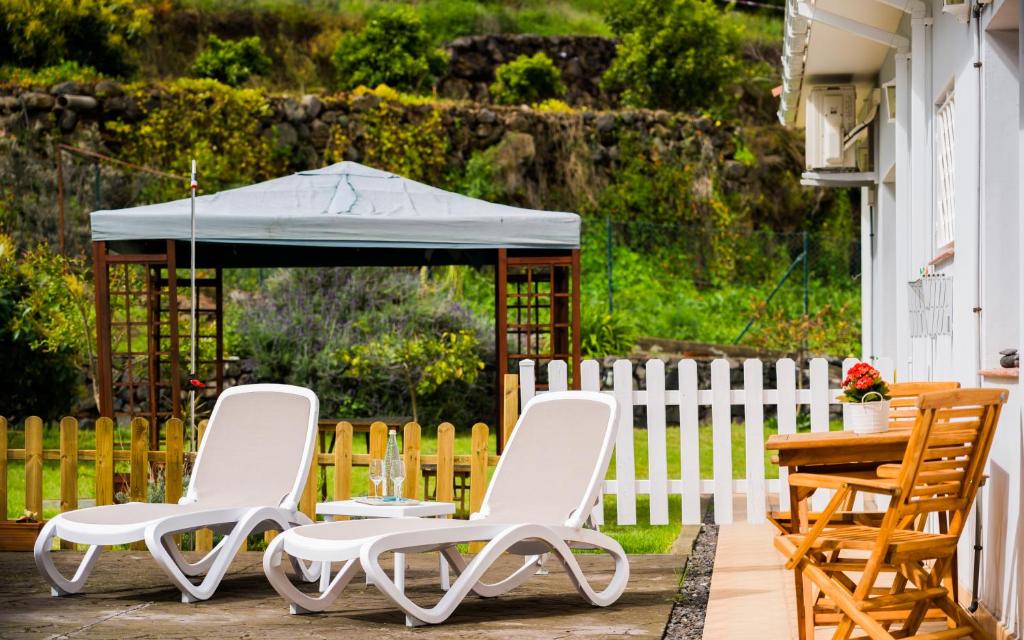 two chairs and a table and an umbrella on a patio at Estudio rural - Nature & Relax in La Orotava