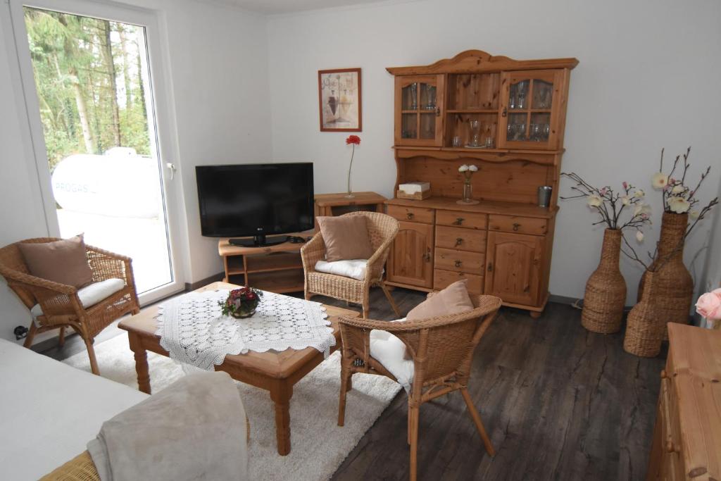 ein Wohnzimmer mit einem TV, einem Tisch und Stühlen in der Unterkunft Ferienhaus kleine Villa in Marschkamp