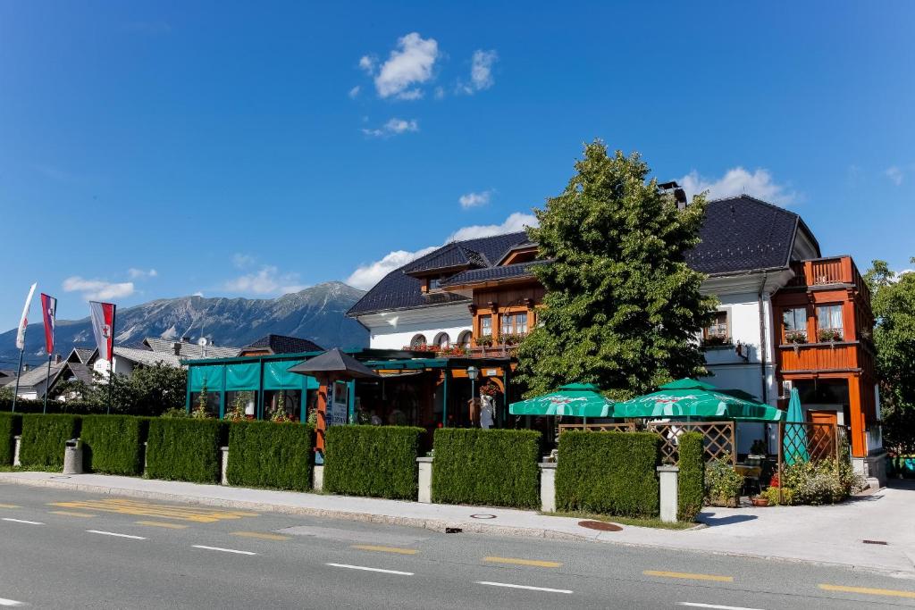 a building with a tree on the side of a street at Guesthouse Tulipan in Lesce