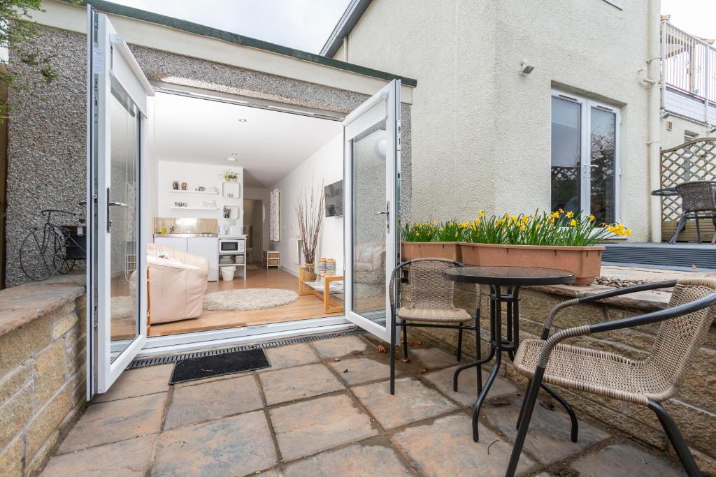 un patio con tavolo e sedie e una camera di Garden Studio Apartment St Andrews - Free Parking a St Andrews