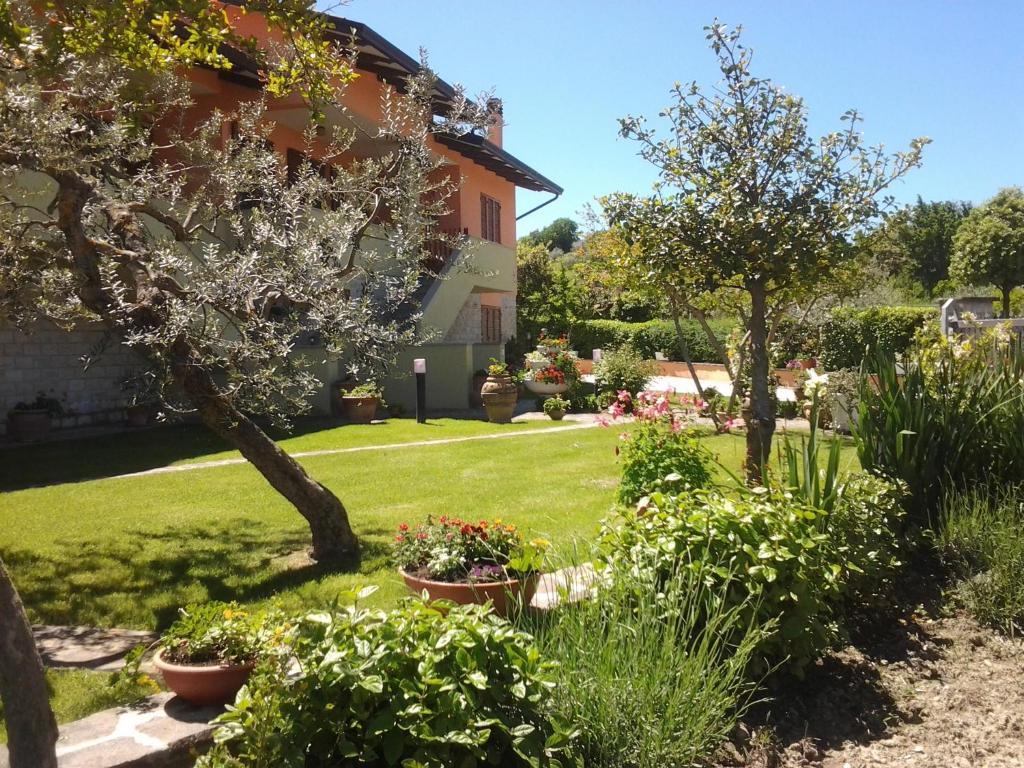 a garden in front of a house with flowers at Poggio La Grognola in Cannara