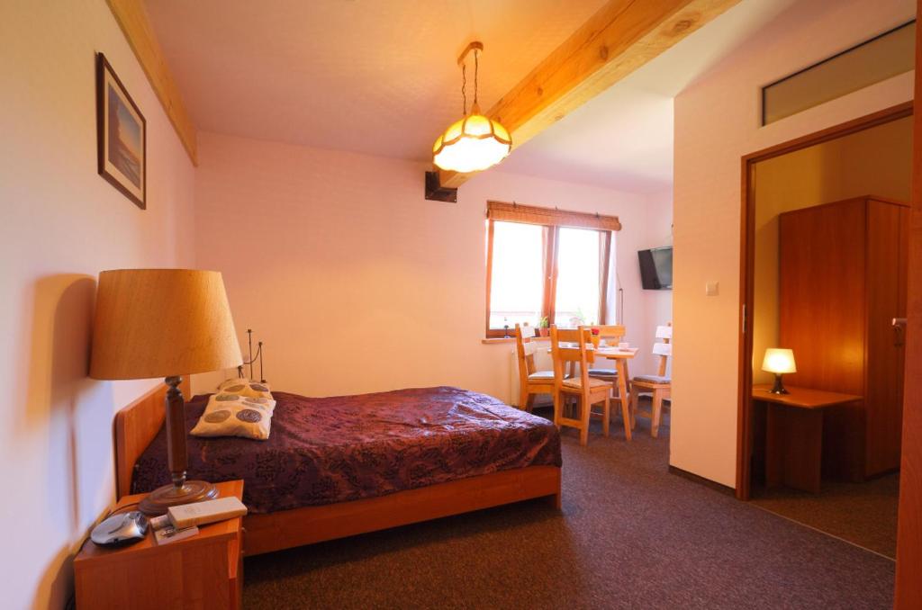 a hotel room with a bed and a dining room at Pensjonat Fala in Ustronie Morskie