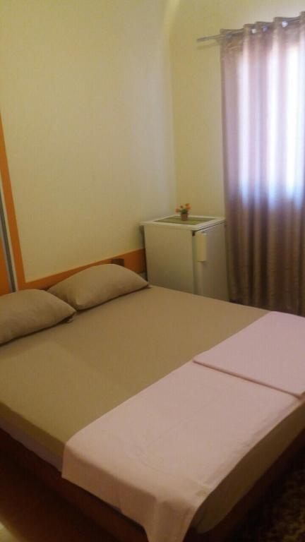 a bedroom with a bed and a window with a curtain at Guesthouse Stankovic in Sutomore