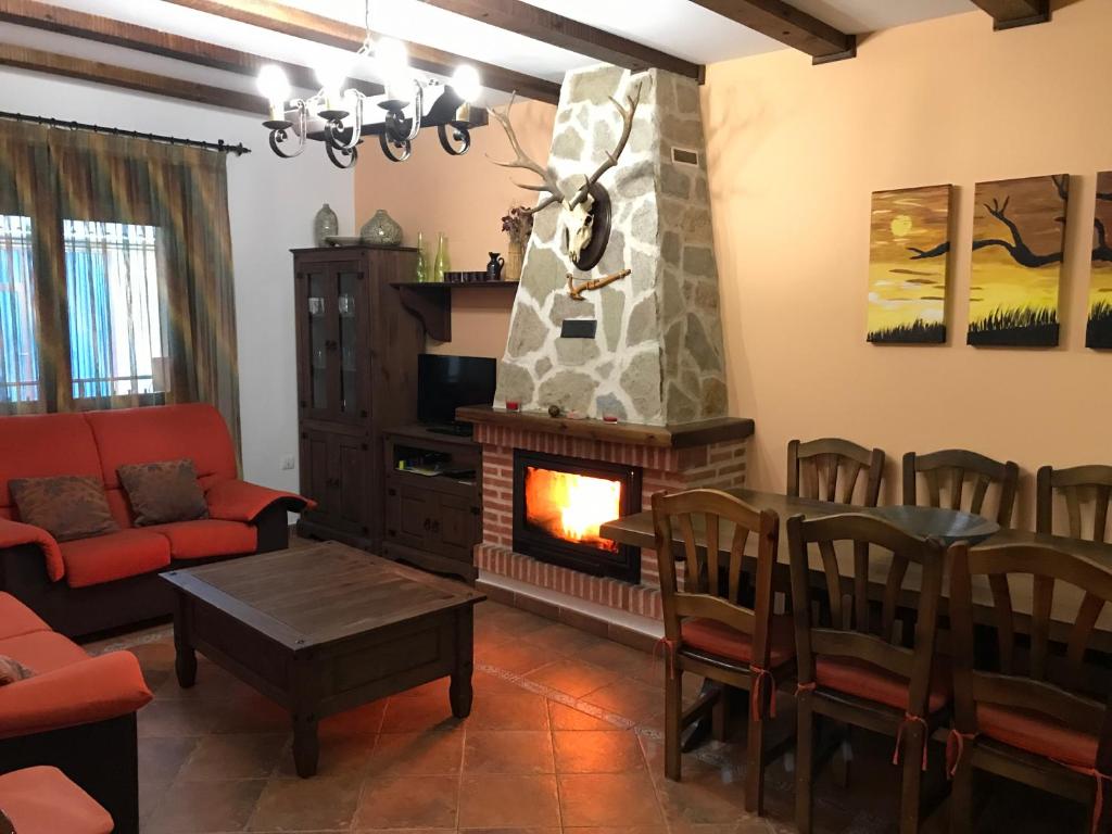 sala de estar con chimenea y sofá rojo en CASA RURAL LA IBIENZA, en Zarzuela del Pinar