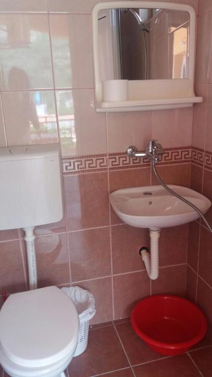 a bathroom with a toilet and a sink and a mirror at Guesthouse Stankovic in Sutomore
