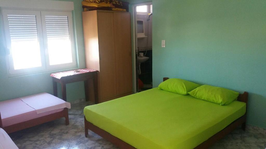 a green bedroom with a bed and a window at Guesthouse Stankovic in Sutomore