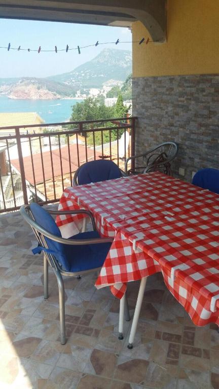 a table and chairs with a red and white checkered tablecloth on top at Guesthouse Stankovic in Sutomore