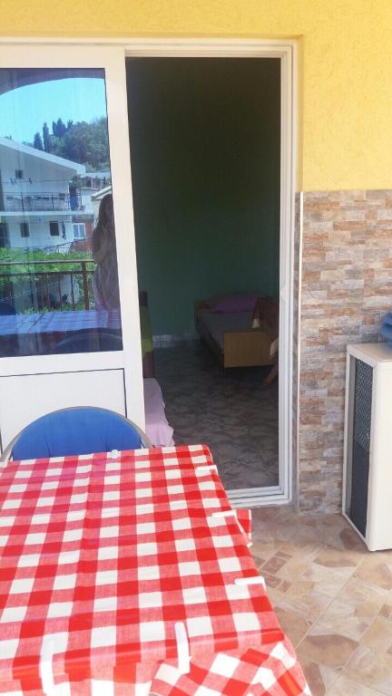 a room with a table and a sliding glass door at Guesthouse Stankovic in Sutomore