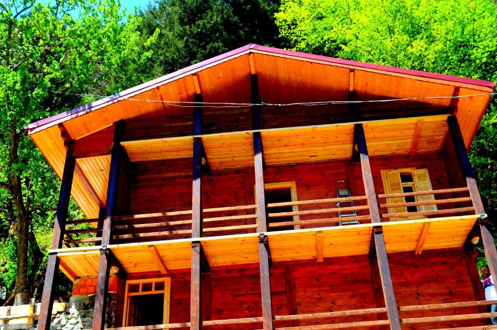 a large wooden cabin with trees in the background at Ozturk Apart in Uzungöl