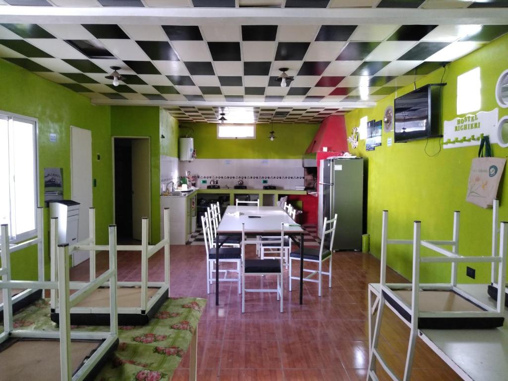 uma cozinha com mesa e cadeiras num quarto em Hostel Richieri em Neuquén