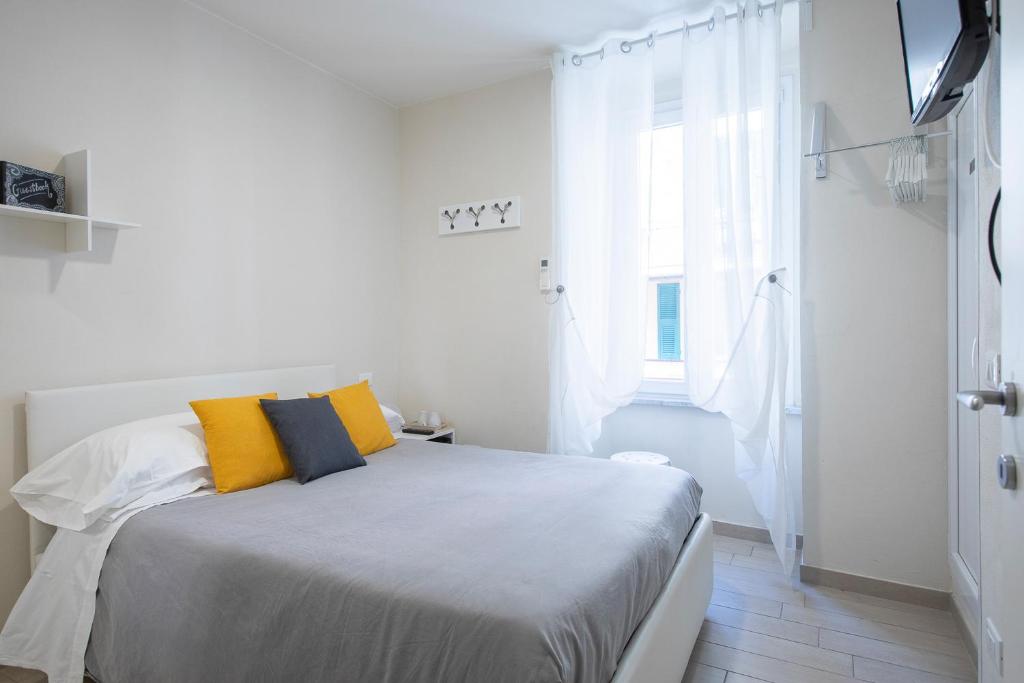 リオマッジョーレにあるJ&Kの白いベッドルーム(黄色い枕のベッド付)