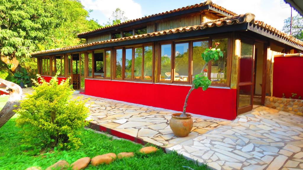 uma pequena casa com um vaso de plantas em frente em Praia da Crioula em Vargem Bonita