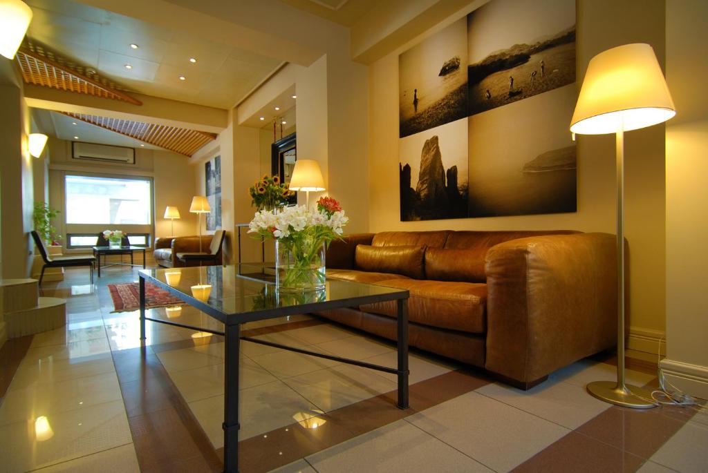 sala de estar con sofá y mesa de cristal en Philippos Hotel, en Atenas
