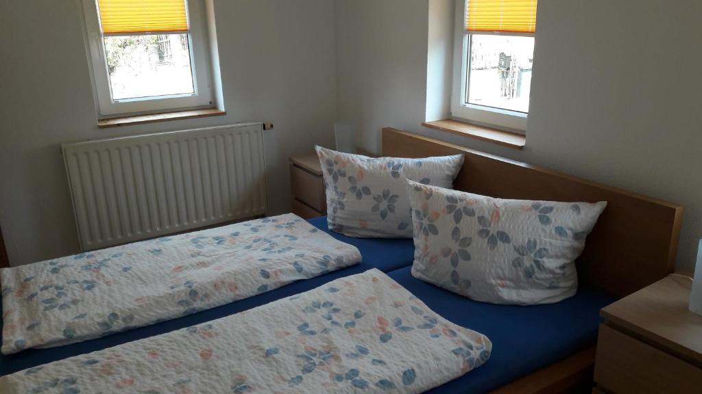 a small bedroom with two beds and two pillows at Ferienhaus Schrammsteinblick in Altendorf