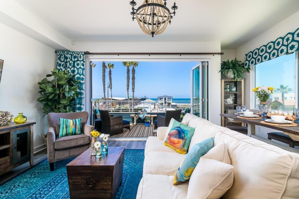 a living room with a white couch and a chandelier at Ocean View 3 Bedrooms Condo, just steps from the park, pier & water! in Imperial Beach