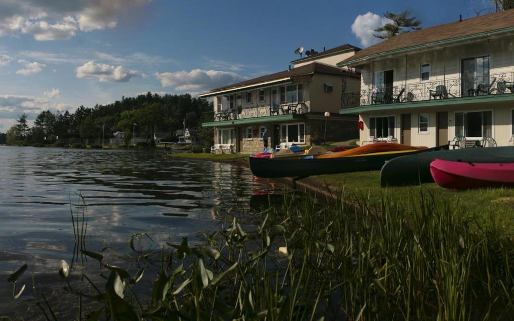 Ein paar Boote stehen neben einigen Häusern. in der Unterkunft Gauthier's Saranac Lake Inn in Saranac Lake