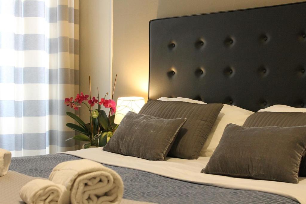 ローマにあるLittle Rose Roomsのベッドルーム1室(黒いヘッドボードと枕付きのベッド1台付)