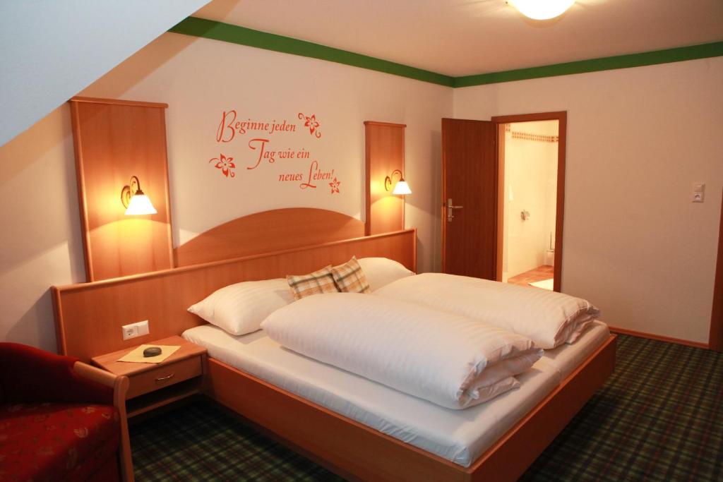 a bedroom with a bed and a red couch at Gasthof Karlwirt in Sankt Andrä im Lungau