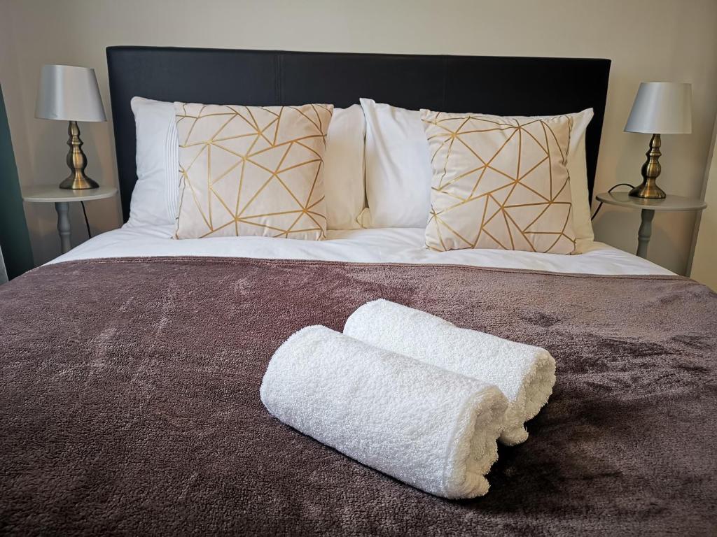 łóżko z białym ręcznikiem na górze w obiekcie Serviced Apartment /Excel/ Olympic city/ O2 arena w Londynie