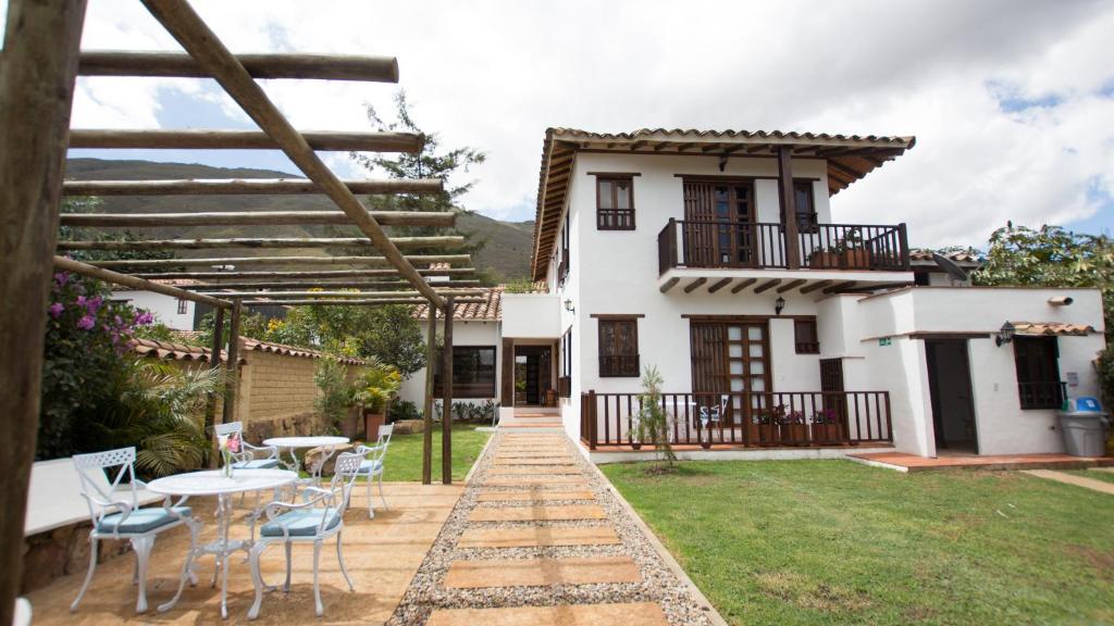 a house with a patio and a table and chairs at Casa Tzabar in Villa de Leyva
