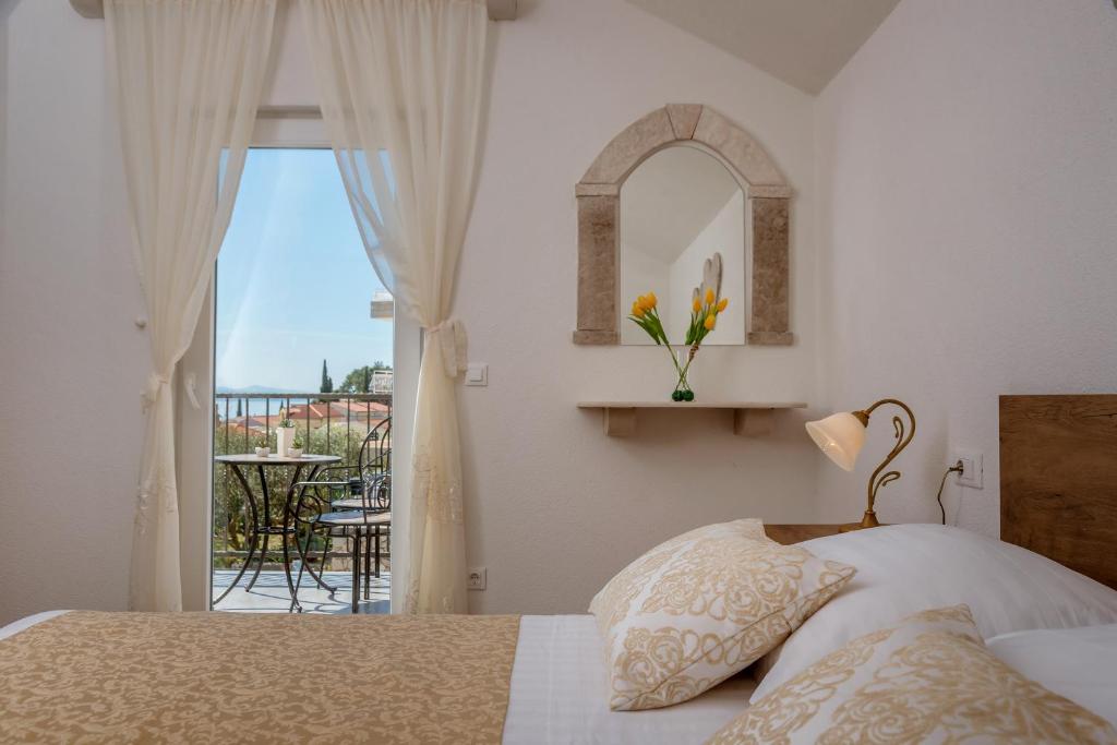 a bedroom with a bed and a view of a balcony at Apartment Cesarica in Baška Voda