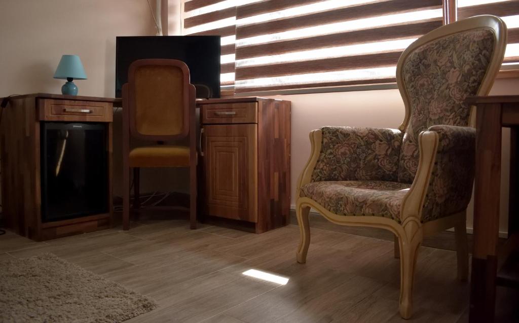 a living room with a chair and a tv at Hotel &quot;VIR&quot; in Velika Plana
