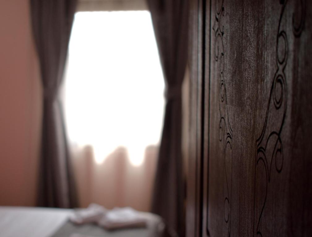 a bedroom with a bed and a window with curtains at Hotel &quot;VIR&quot; in Velika Plana