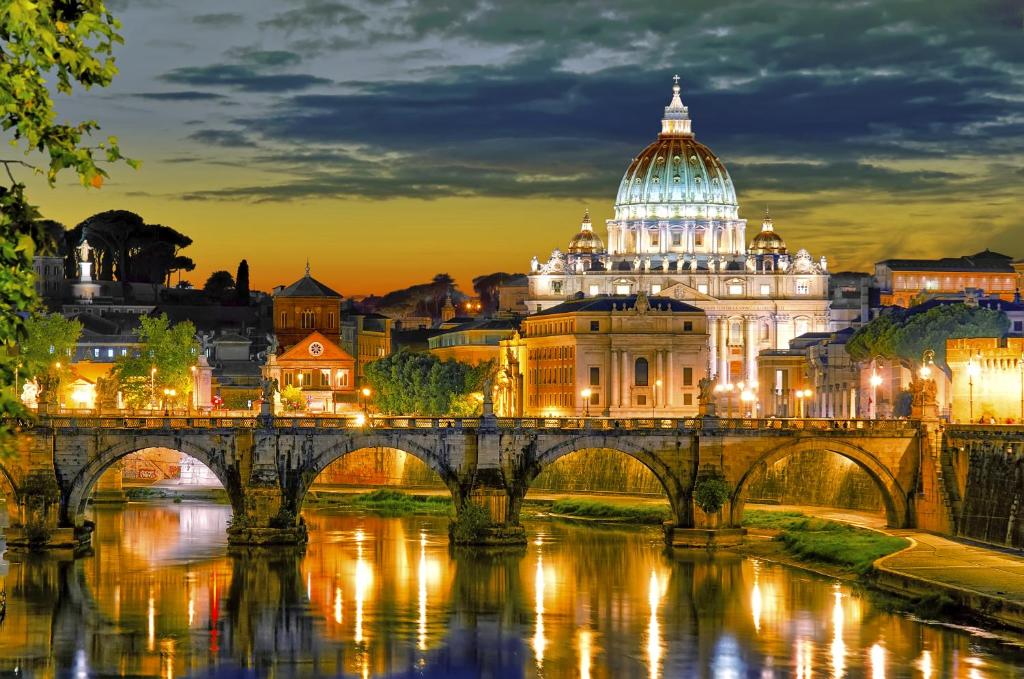 un ponte su un fiume di fronte a un edificio di Vatican Royal Apartment a Roma