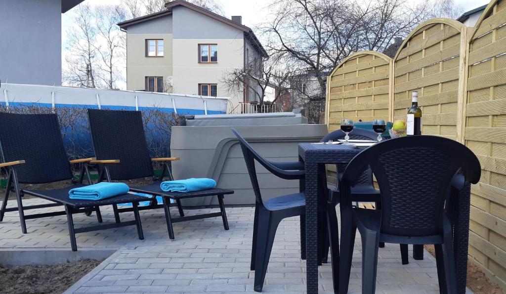 einen Tisch und Stühle auf einer Terrasse mit einem Zaun in der Unterkunft Apartments with spa Jacuzzi and sauna in Vilnius