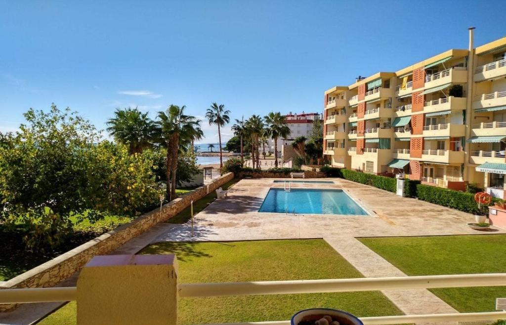 una piscina di fronte a un edificio di Primera Linea de Mar con Piscina en EbreHogar a Sant Carles de la Ràpita