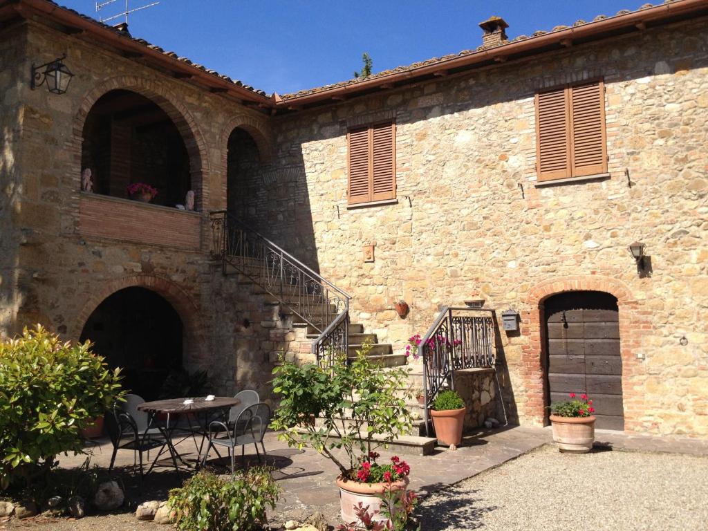 a stone building with a table and a patio at Agriturismo Torrevecchia in Pienza