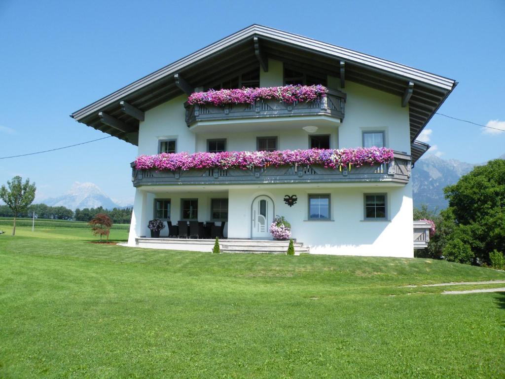a white house with flowers on the balcony at Gästehaus Weber in Oberperfuss