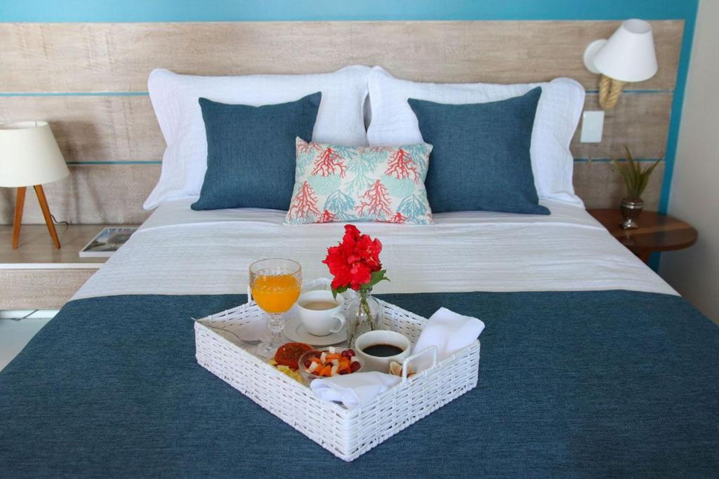 taca z jedzeniem i sokiem pomarańczowym na łóżku w obiekcie Recanto do Sol w mieście Praia de Araçatiba