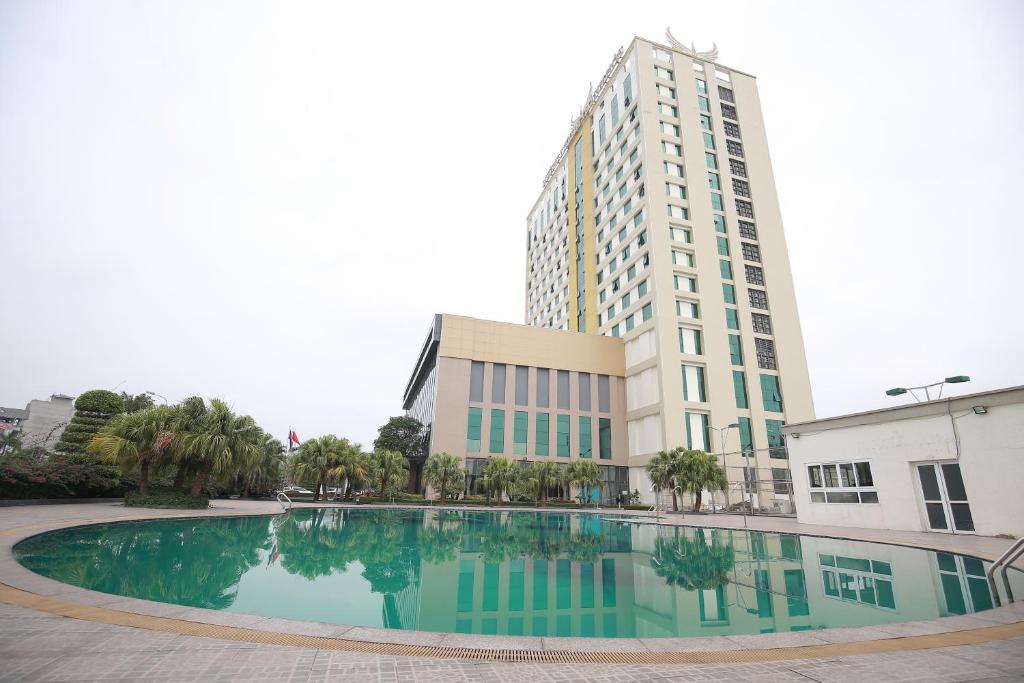 a building with a large swimming pool in front of a building at Muong Thanh Grand Thanh Hoa Hotel in Thanh Hóa