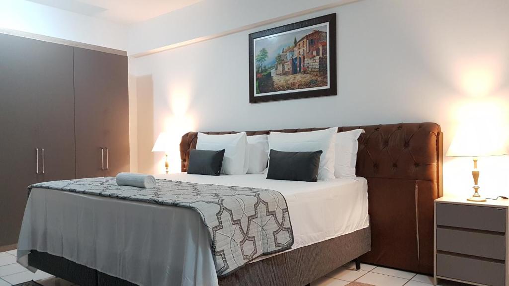 a bedroom with a large bed with white sheets and pillows at B & A Suites Inn Hotel - Quarto Luxo Gold in Anápolis