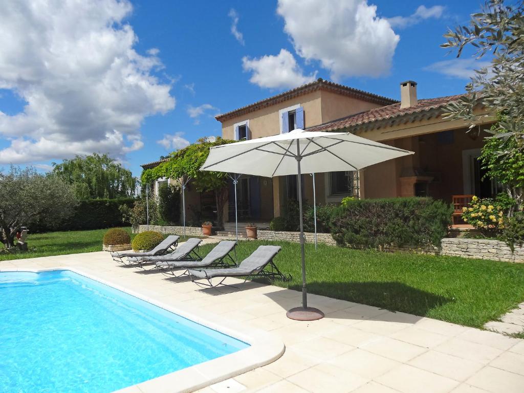 - une piscine avec des chaises et un parasol à côté d'une maison dans l'établissement Villa Le Bouloulou by Interhome, à Velleron