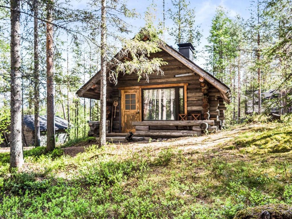 eine Blockhütte im Wald mit einer Veranda in der Unterkunft Holiday Home Tievatupa 2- pienempi by Interhome in Ylläsjärvi