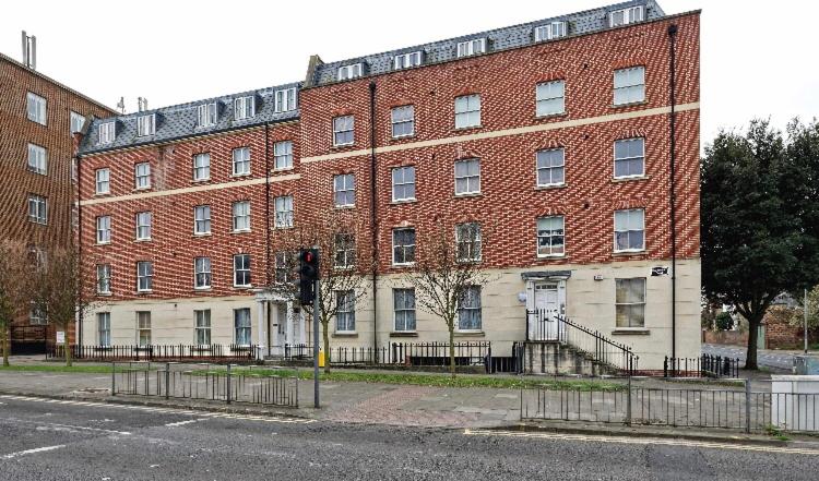 a large brick building on the corner of a street at Copperfield Apartment in Canterbury