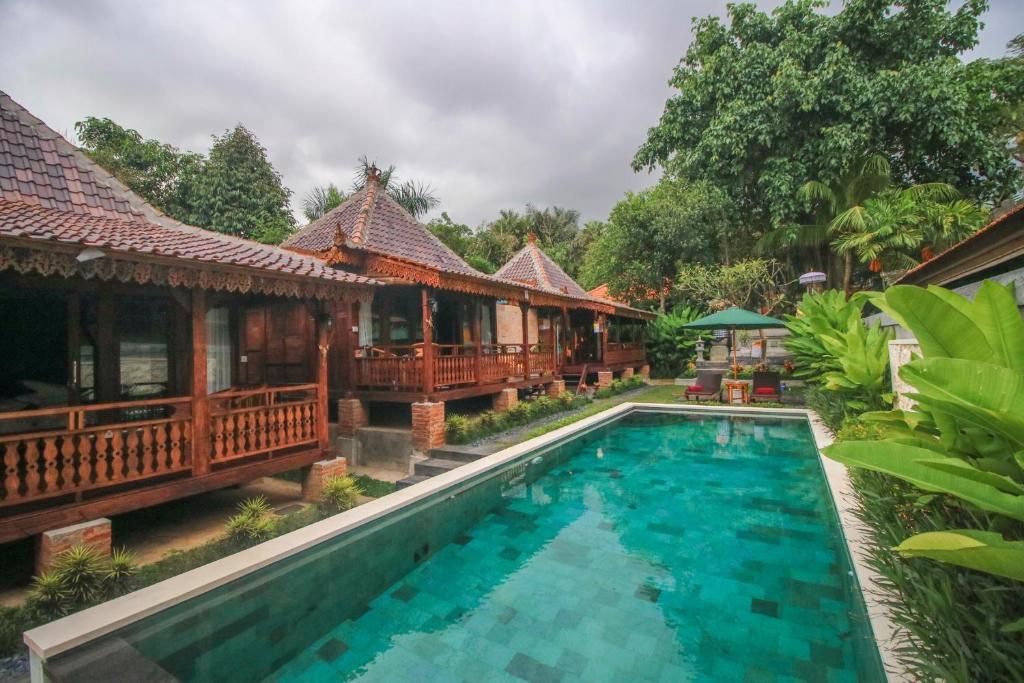 a villa with a swimming pool in a resort at Ari Cottages Ubud in Ubud