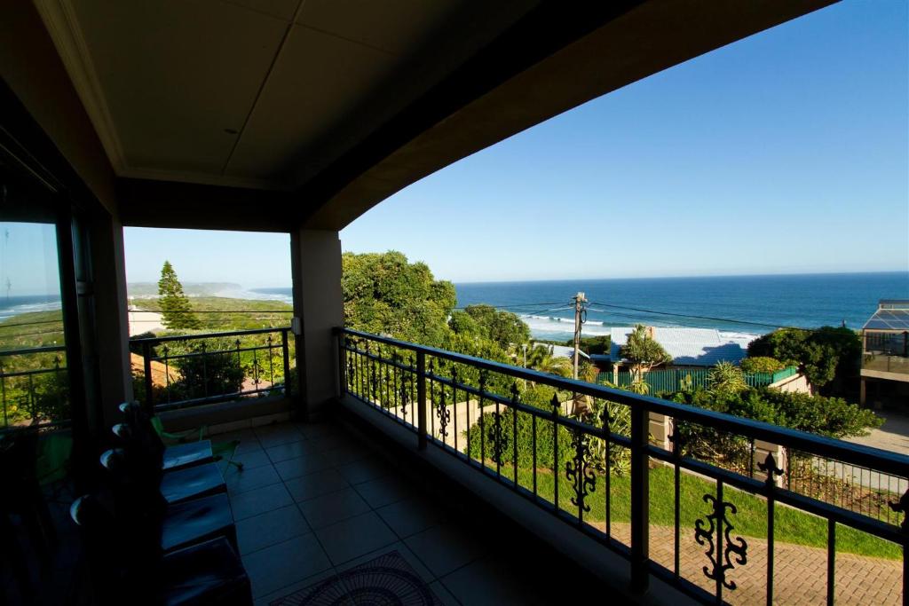 a balcony with a view of the ocean at Tranquil Shores in Wilderness