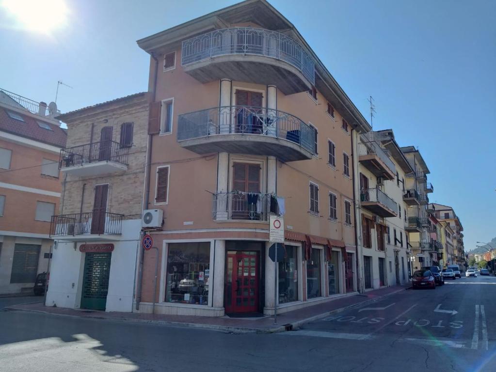 un bâtiment rose avec un balcon dans une rue de la ville dans l'établissement Casa Mar.e, à Grottammare