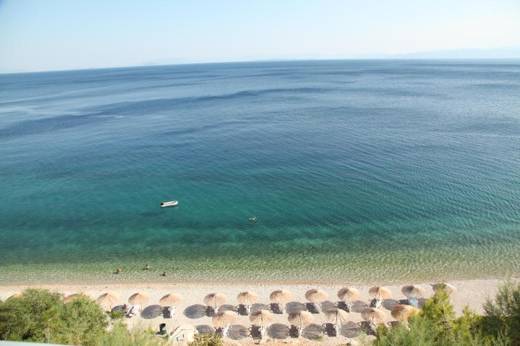 eine Luftansicht auf einen Strand mit einem Boot im Wasser in der Unterkunft Hotel Cokkinis in Megara