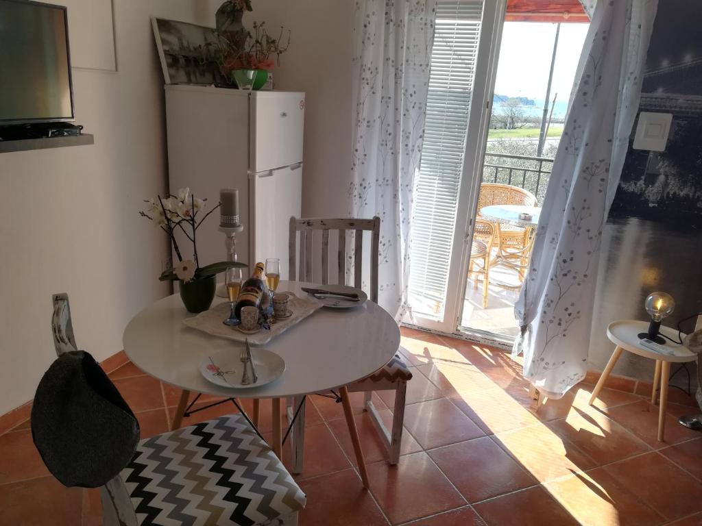 a table and chairs in a room with a refrigerator at Guesthouse Porec in Poreč