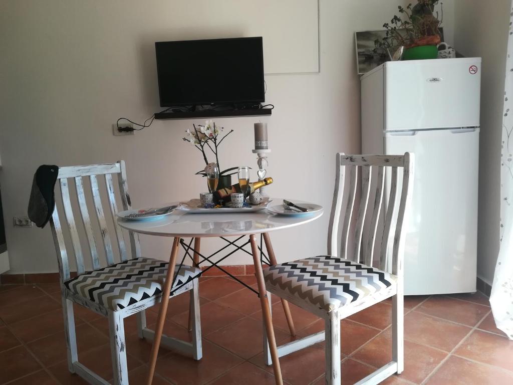 a small table with two chairs and a television at Guesthouse Porec in Poreč