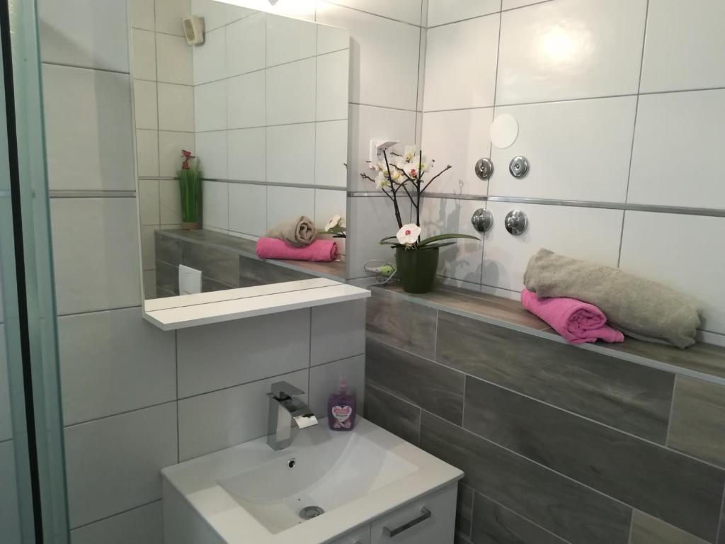 a white bathroom with a sink and a mirror at Guesthouse Porec in Poreč