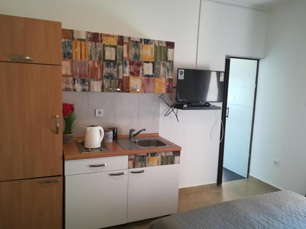a kitchen with a sink and a tv on the wall at Guesthouse Porec in Poreč
