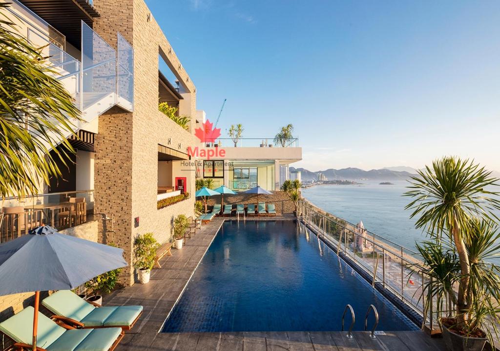 a hotel swimming pool with a view of the water at Maple Hotel & Apartment in Nha Trang