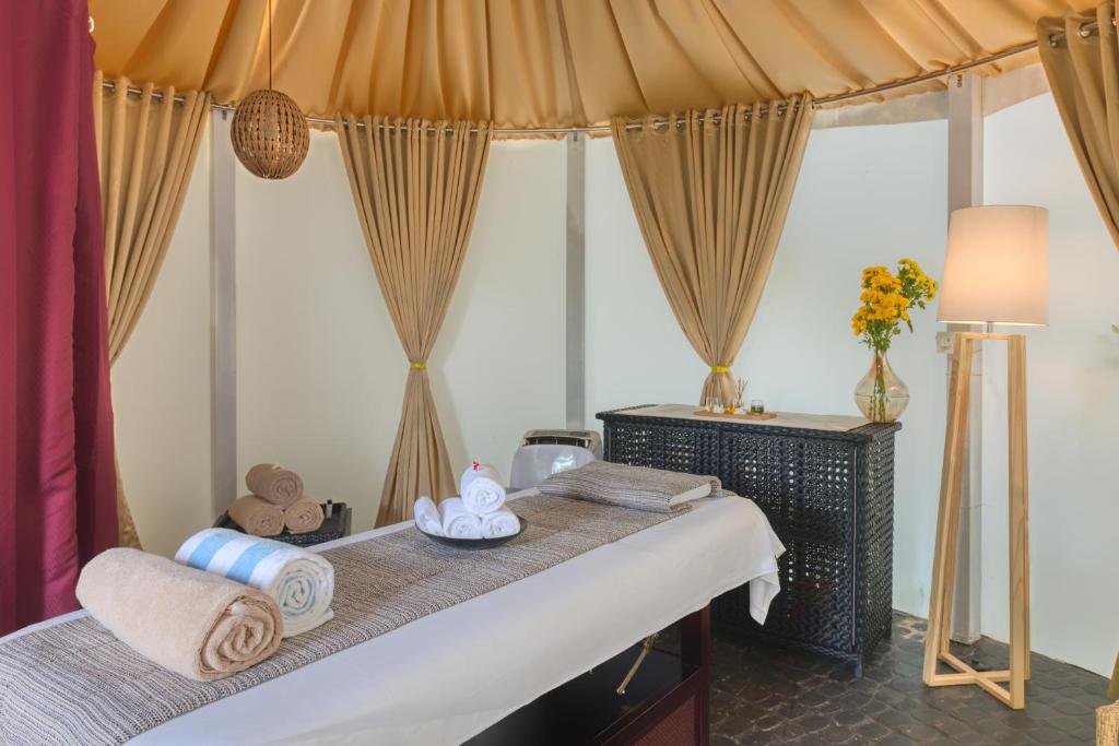 a bedroom with a bed with towels and a lamp at Azaya Beach Resort Goa in Benaulim